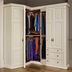 an open closet with clothes hanging on the doors and drawers in it, next to a hardwood floor