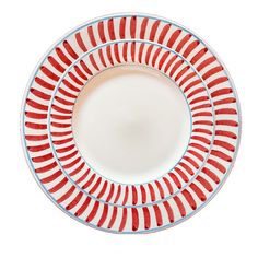 a red and white plate with stripes on the rim, set against a white background