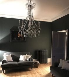 a living room with two couches and a chandelier hanging from the ceiling