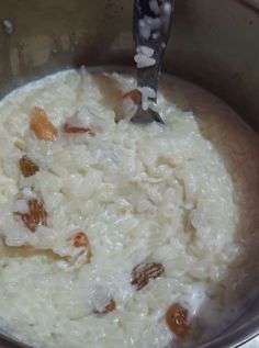 rice and nuts are mixed together in a pot with a ladle full of water