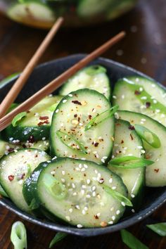 cucumber salad in a bowl with chopsticks and sesame seeds on the side