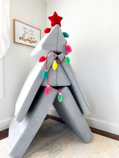 a christmas tree made out of cement blocks with lights on it and a star hanging from the top