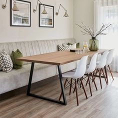 a long table with chairs around it in front of a couch