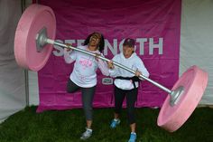 two women are doing exercises with pink barbells in front of a sign that says strength