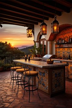 an outdoor bar with several stools and lights hanging from it's ceiling, overlooking the mountains