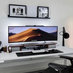 a flat screen tv sitting on top of a white desk