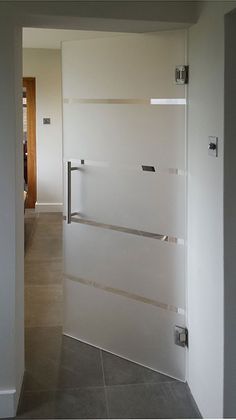 an open door leading to a hallway with white walls and tile flooring on either side