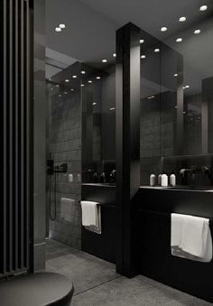 a black and white photo of a bathroom with sinks, mirrors and towels hanging on the wall