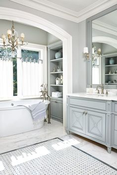 a bathroom with a tub, sink, and mirror in the middle of it's room