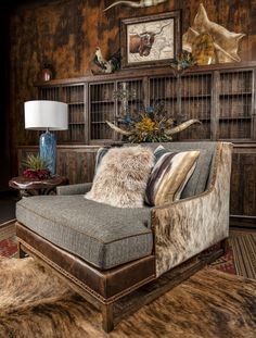 a living room with a couch, chair and lamp on the side table in front of an animal print rug