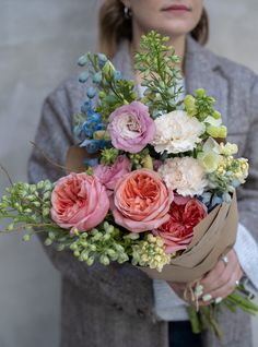 a woman holding a bouquet of flowers in her hands