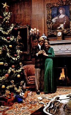 a man and woman standing in front of a christmas tree