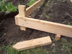 a wooden bench sitting in the middle of a field next to some dirt and grass