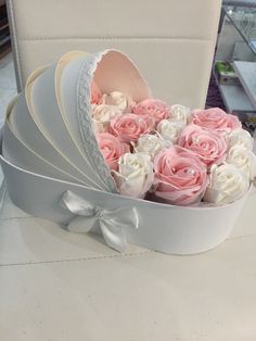 a white box with pink and white roses in it