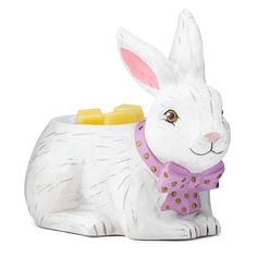 a white rabbit figurine with a pink bow tie on it's neck