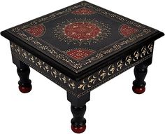 a black table with red and gold designs on it's top, sitting in front of a white background