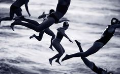 several people are jumping into the air on surfboards