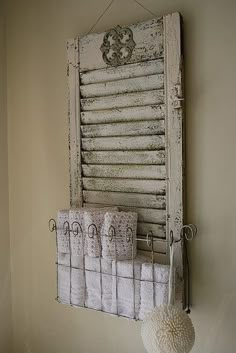 an old window is hung on the wall with some towels and a ball hanging from it