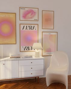 a white chair sitting in front of a dresser next to a lamp and pictures on the wall