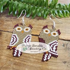 an owl shaped beaded earrings on top of a wooden table