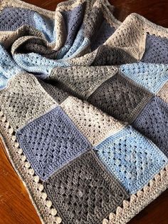 a crocheted blanket on top of a wooden table