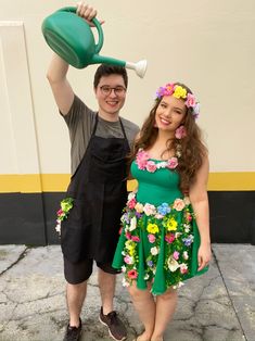 the man and woman are dressed up as flower power characters, one holding a green watering can