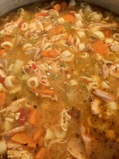 a pot filled with chicken noodle soup on top of a stove