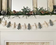 a mantel decorated with pine cones and garland