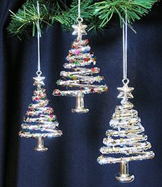 three glass christmas trees hanging from a tree branch