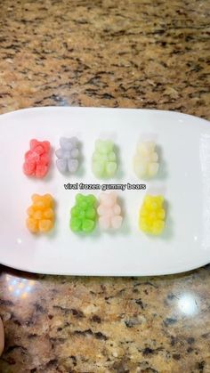 a white plate topped with gummy bears on top of a counter