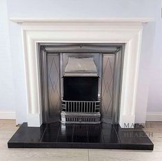 a fireplace with a black mantle and white walls