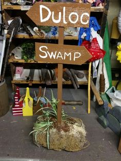 a wooden sign that says duloc swamp in front of a shelf with other items