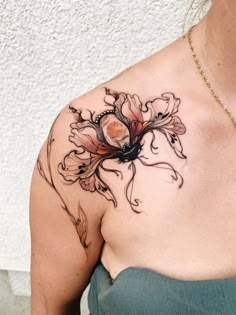 a woman's shoulder with a flower tattoo on her left arm and the bottom half of her body