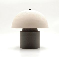 a black table lamp with a white shade on it's top and bottom part