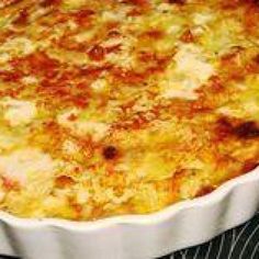 a casserole dish sitting on top of a stove in a white pan with cheese