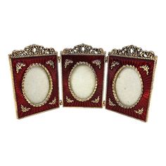 three red and gold frames with ornate designs on the sides, one is empty or closed