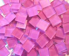 a pile of purple glass tiles sitting on top of a table