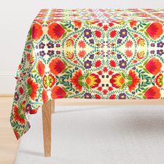 an image of a colorful table cloth with flowers on it in the middle of a room