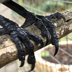 two black hands are attached to a piece of wood