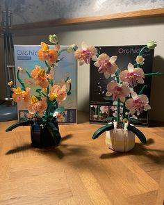 two vases filled with flowers on top of a wooden table