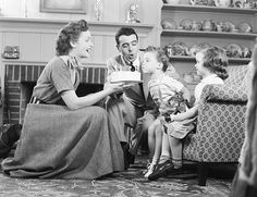 an old black and white photo of a family eating cake