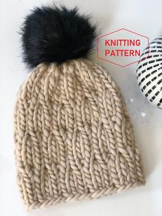 a knit beanie with a black pom - pom on top and the knitting pattern