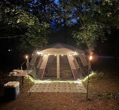 a tent is lit up at night with lights on the outside and in the inside