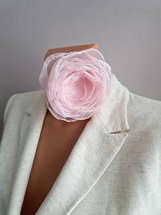 a woman wearing a pink flower on her collar