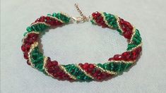 a bracelet with red, green and gold beads