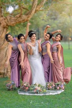 a group of women standing next to each other on top of a lush green field