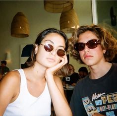 two people sitting at a table wearing sunglasses