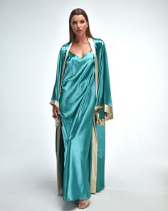 Echoing the vibrant allure of Tokyo's bustling streets, the Tokyo Satin Robe and Nightgown Set captivates with its captivating charm. Crafted from luxurious satin in a striking turquoise hue, this set exudes elegance and sophistication. The intricate gold accents add a touch of opulence, elevating the ensemble to a new level of glamour. Robe:  ✓ ankle length ✓ wrap over style ✓ two sets of inside ties ✓ tie included. Nightgown:  ✓ Mid-open V cut back ✓ Shoulder straps with length regulation.  Ma Luxury Green Silk Evening Dress, Silk Maxi Dress For Night, Satin Floor-length Dress For Night, Floor-length Satin Dress For Night, Elegant Green Sleepwear For Night, Elegant Green Night Sleepwear, Elegant Green Dress For Wedding Night, Elegant Green Satin Sleepwear, Elegant Long Dresses For Night