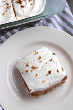 a piece of cake sitting on top of a white plate next to a glass dish