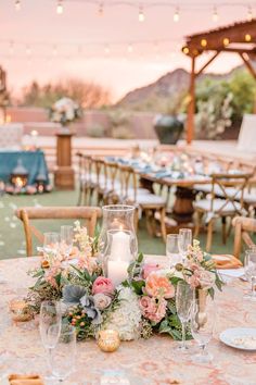 the table is set with flowers and candles